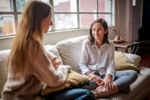 teen and mom on couch talking.